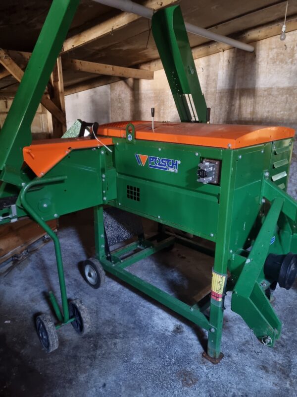 Orange and green Posch kindling machine in shed